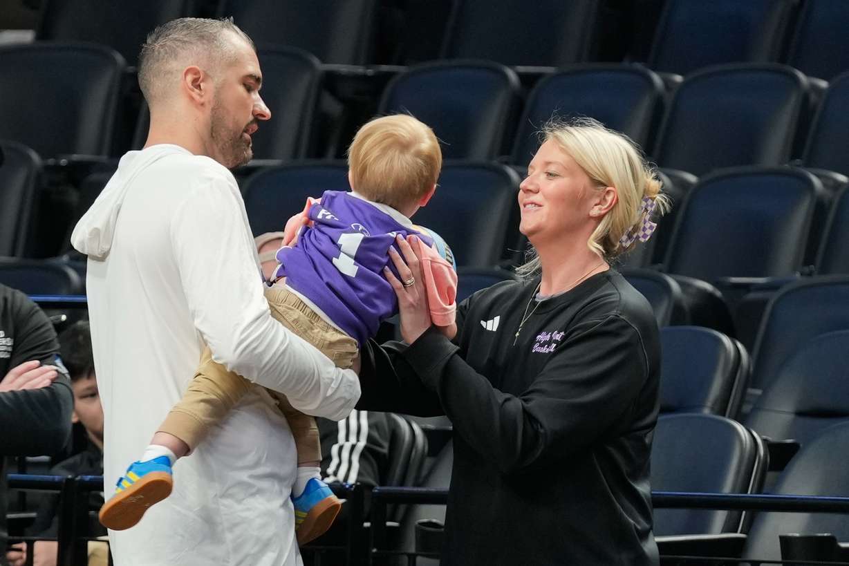 High Point head coach Flynn Clayman, left, hands his son, Quinn, to his wife Katie Clayman, assistant coach for the High Point women's basketball team, right, during practice prior to the first round of the NCAA college basketball tournament on Wednesday, March 18, 2026, in Portland, Ore.