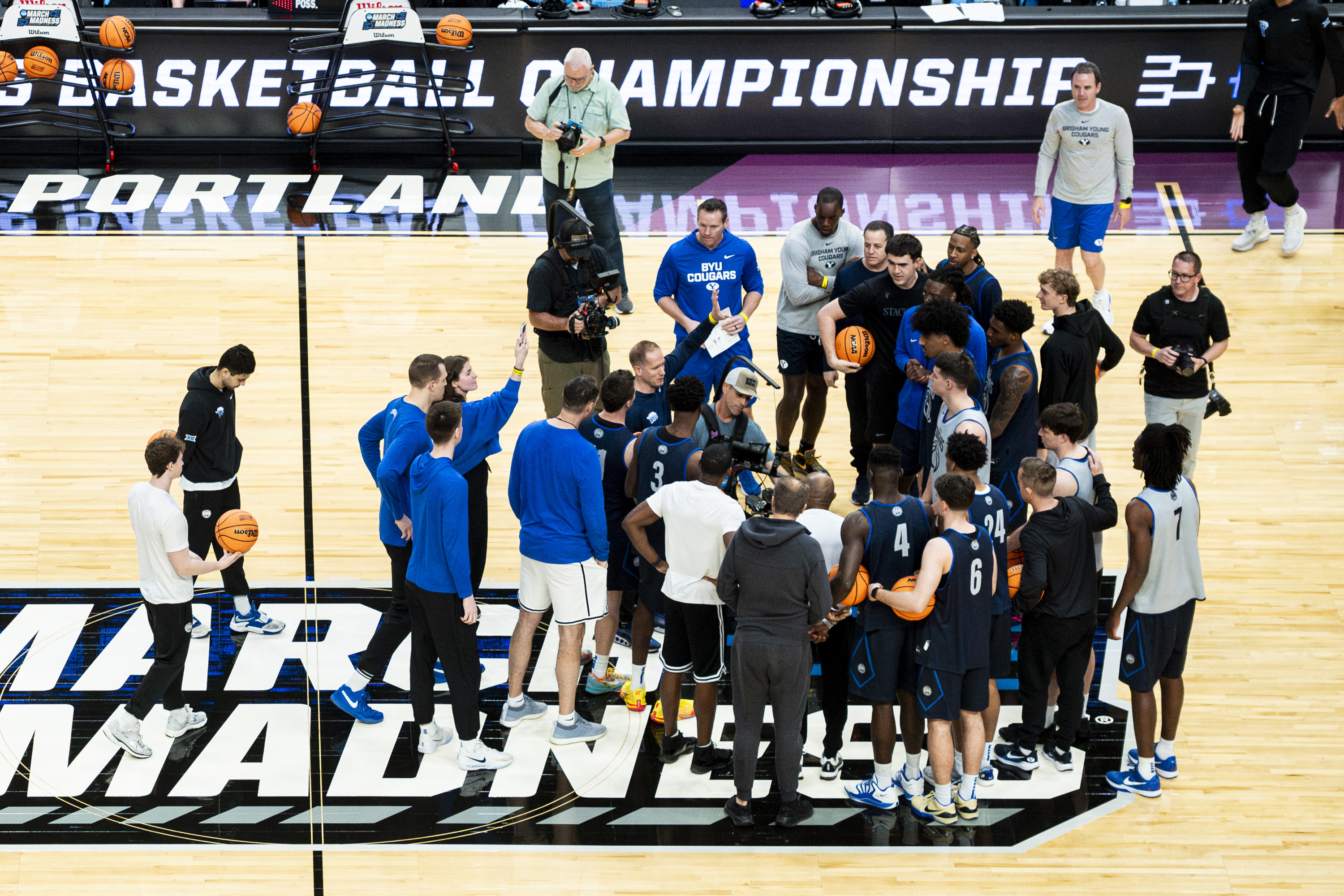 BYU head coach Kevin Young talks with his players as they and coaches huddle during a practice the day before a first-round college basketball game against Texas in the NCAA Tournament held at the Moda Center in Portland, Oregon, on Wednesday, March 18, 2026.