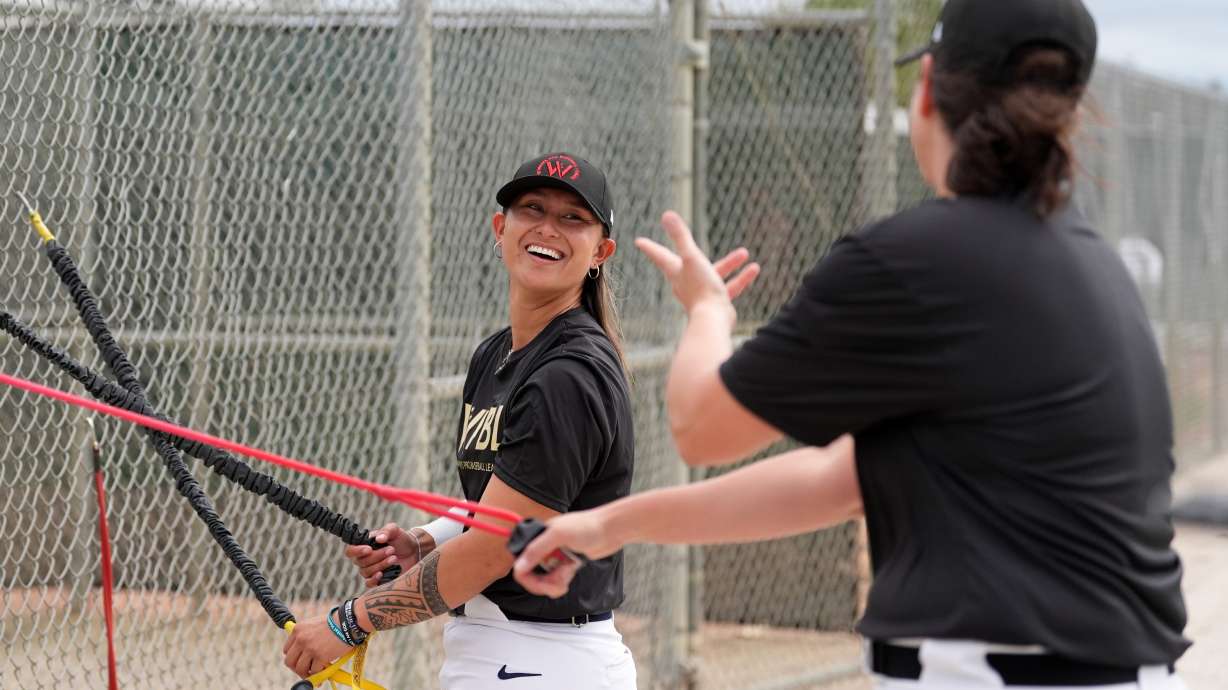 Kelsie Whitmore talks with another player as they use resistance bands during a Women's Pro Baseball League (WPBL) practice, Wednesday, March 18, 2026, in Fort Myers, Fla.