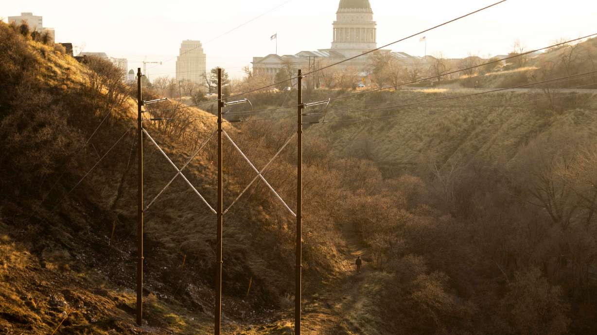 A man walks his dog along snowless hills in City Creek Canyon on Feb. 2. Salt Lake City announced Thursday it's returning to its water shortage contingency plan. Gov. Spencer Cox expects others will follow after this year's low snowpack.