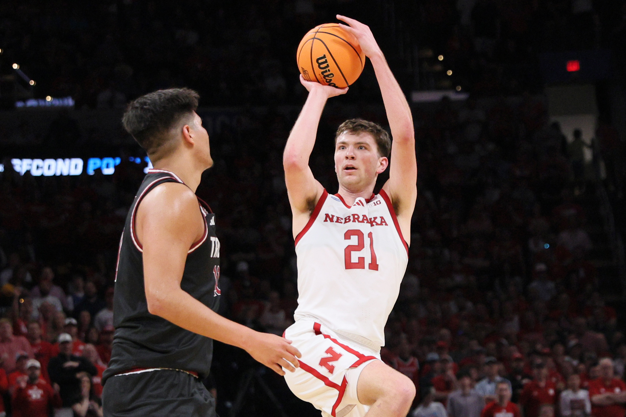 Nebraska forward Pryce Sandfort (21) looks to shoot over Troy forward Victor Valdes, left, during the first half in the first round of the NCAA college basketball tournament, Thursday, March 19, 2026, in Oklahoma City.