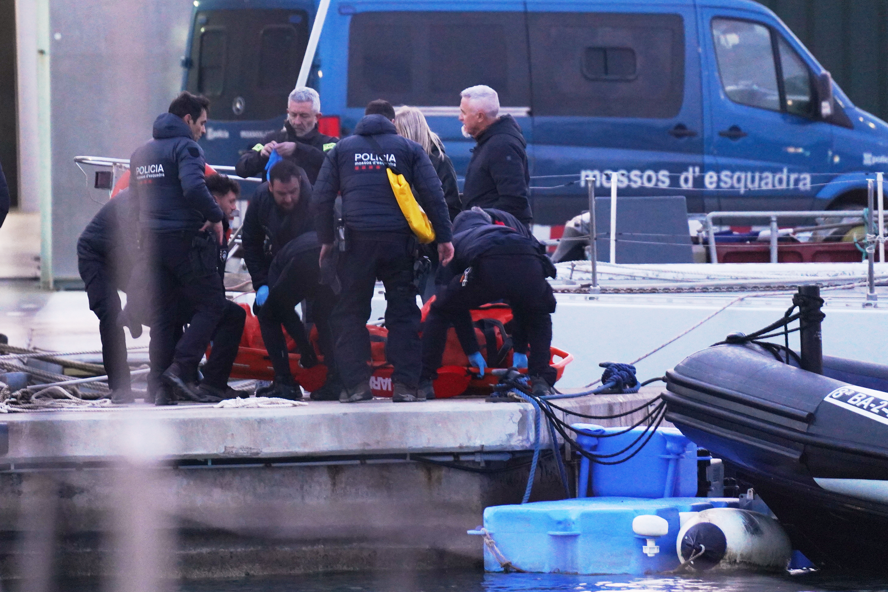 Police officers carry the body of a person found in the waters off the Port of Barcelona, Spain, on Thursday.