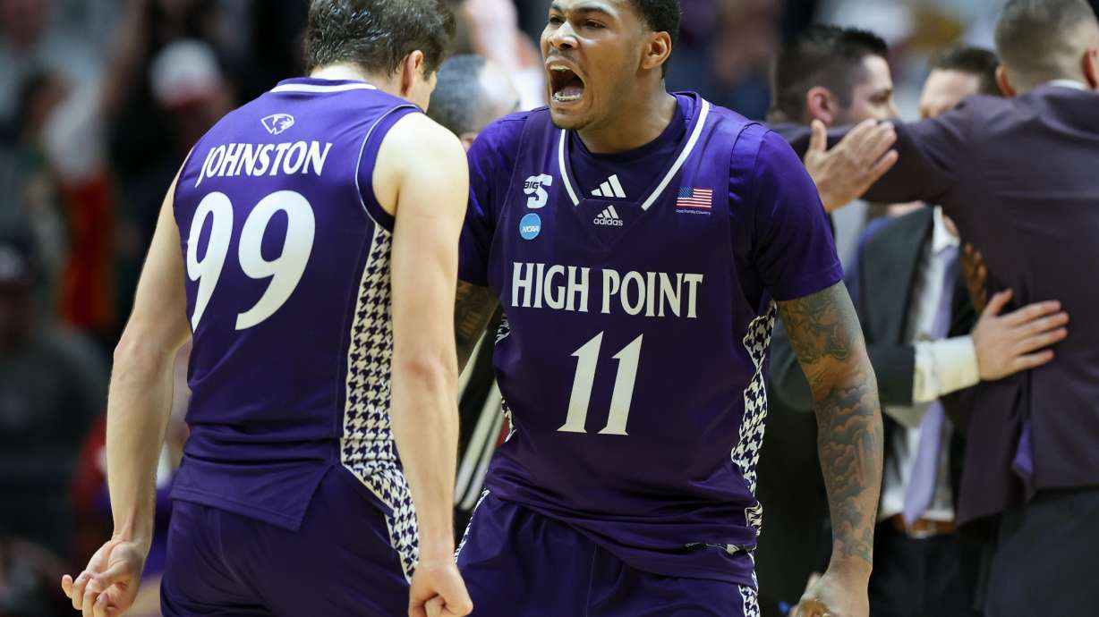 High Point forward Cam'ron Fletcher (11) celebrates with guard Chase Johnston (99) during the second half in the first round of the NCAA college basketball tournament against Wisconsin, Thursday, March 19, 2026, in Portland, Ore.