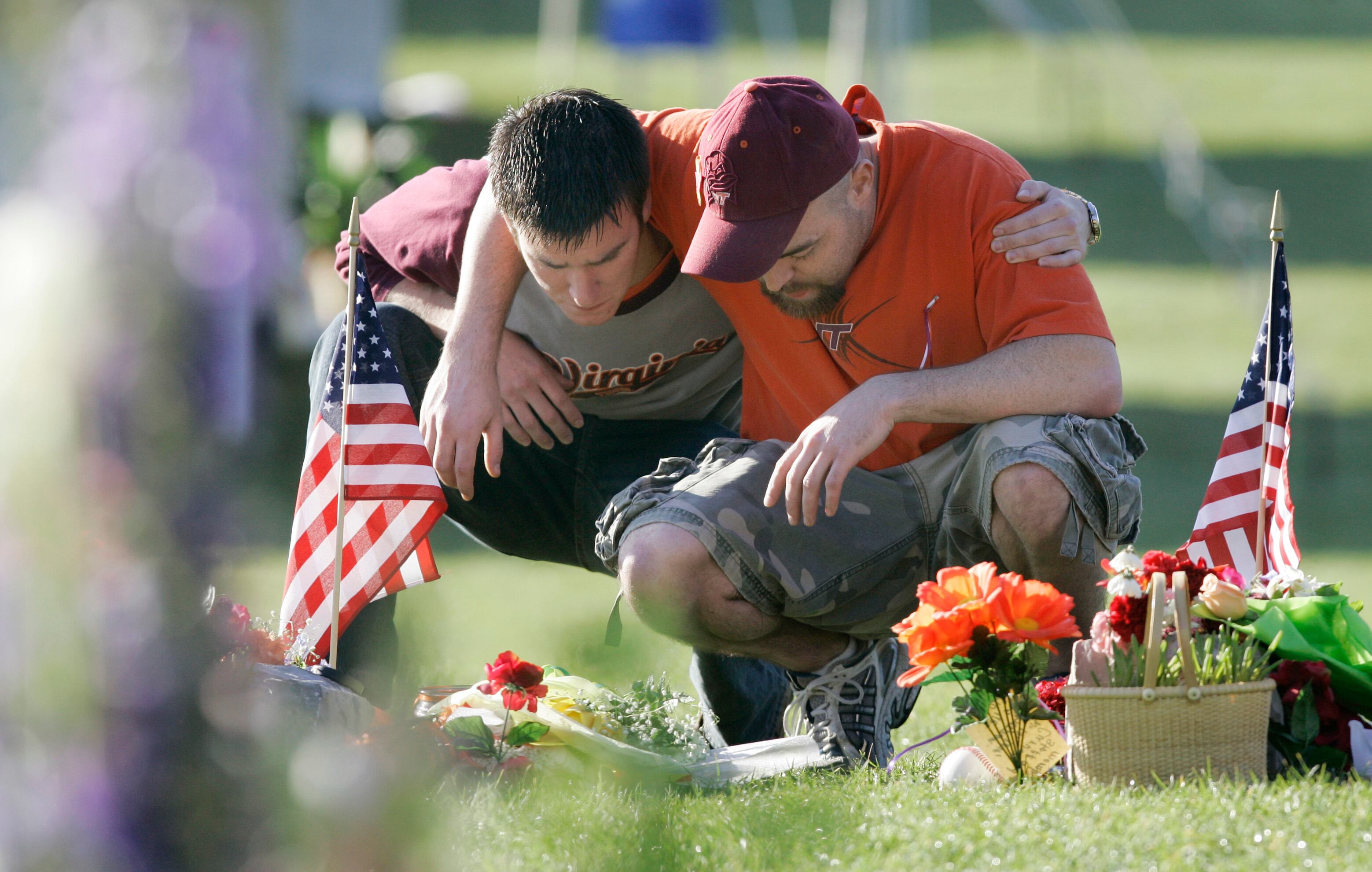 Joshua Stevens, of Blacksburg, Va., embraces former Virginia Tech student Russell Miller of Richmond, Va., as they visit the makeshift memorial on the campus of the university in Blacksburg, Va., April 21, 2007. A survivor of the shooting spoke at the University of Utah's annual campus safety summit on Thursday.