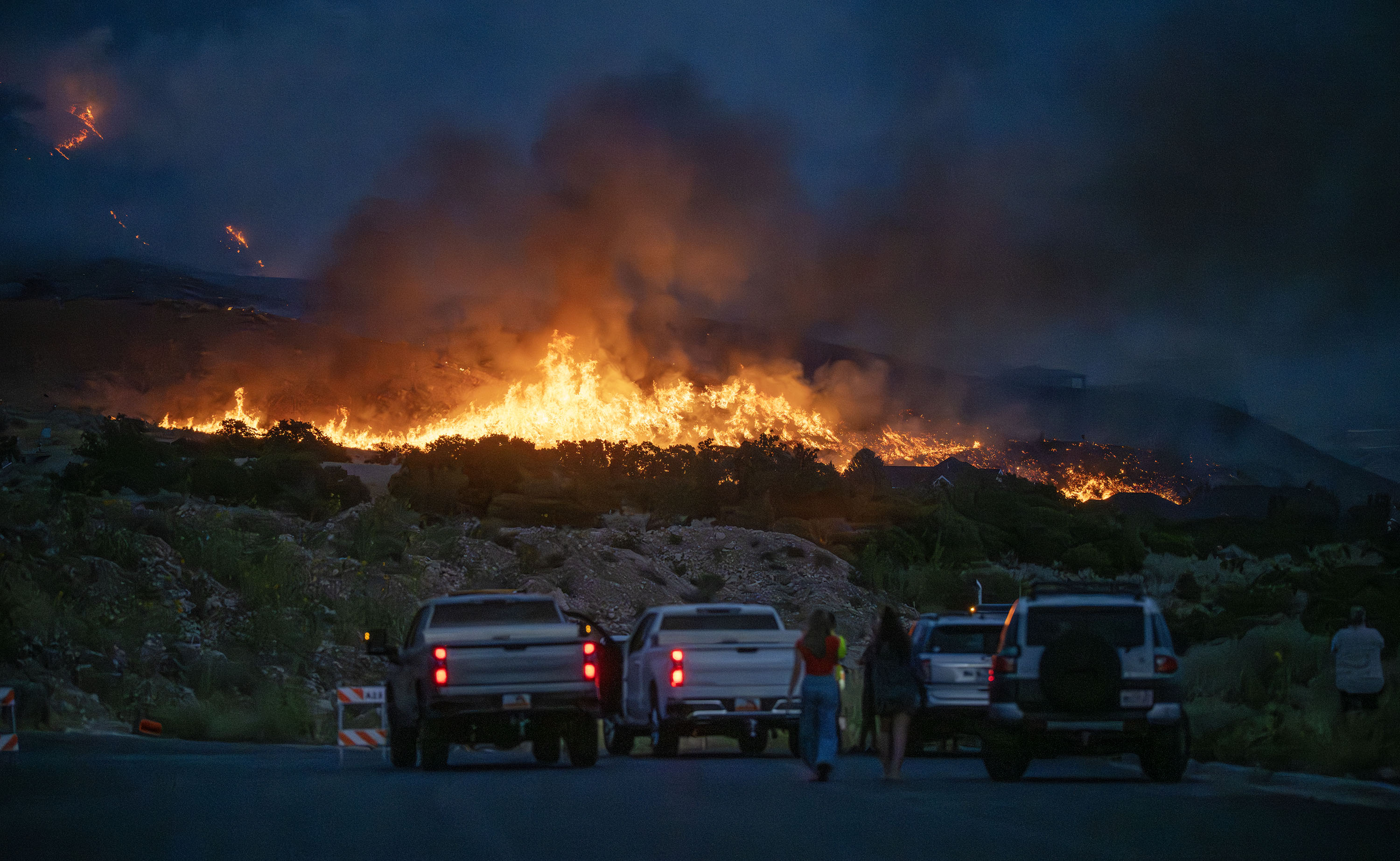 Residents gather to watch the fire burning near homes and on the mountain in North Ogden on Aug. 13. A low snowpack year could raise the risk of wildfires this summer.