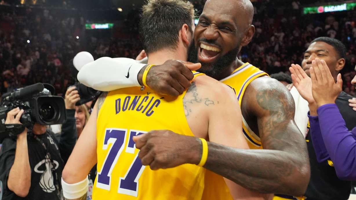 Los Angeles Lakers guard Luka Doncic (77) and forward LeBron James, right, embrace after defeating the Miami Heat in an NBA basketball game, Thursday, March 19, 2026, in Miami.