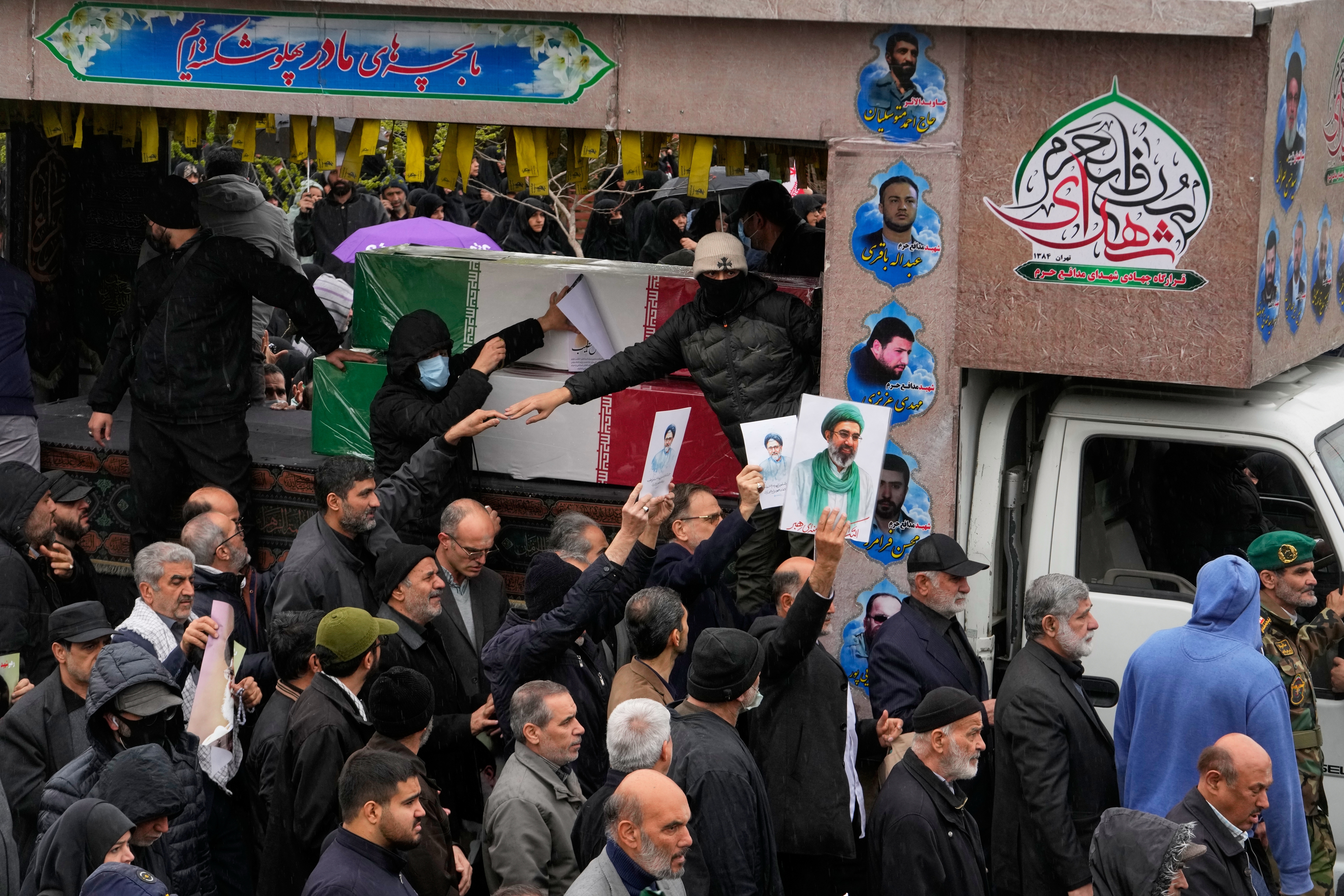 Iranians follow the funeral procession of Iran's intelligence minister Esmail Khatib and, according to Iranian officials, his wife and daughter, in Tehran, Iran, Friday.