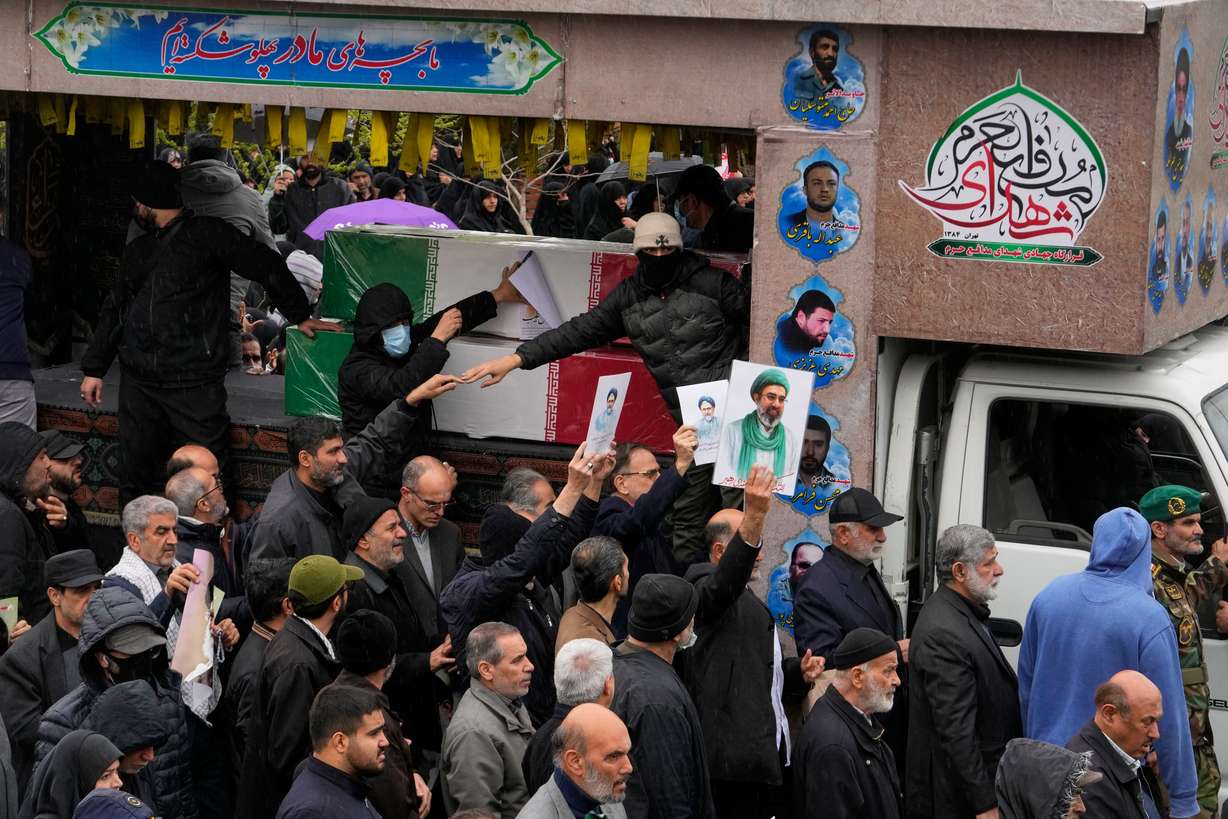 Iranians follow the funeral procession of Iran's intelligence minister Esmail Khatib and, according to Iranian officials, his wife and daughter, in Tehran, Iran, Friday.