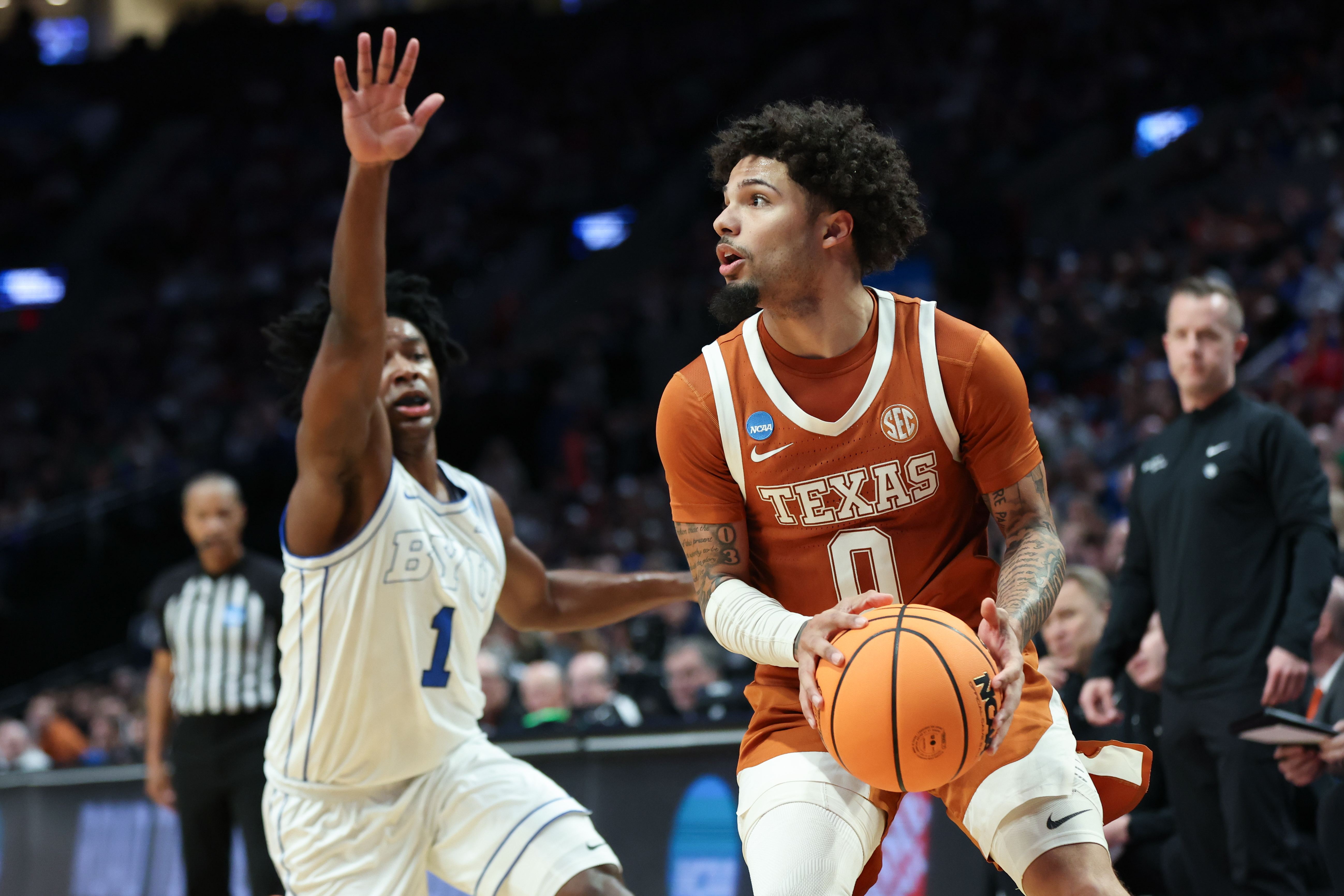 Texas guard Jordan Pope (0) looks to shoot as BYU guard Robert Wright III (1) defends during the first half in the first round of the NCAA college basketball tournament Thursday, March 19, 2026, in Portland, Ore. 