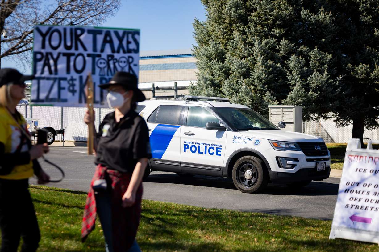 A Department of Homeland Security vehicle exits the premises as people protest at an Immigration and Customs Enforcement office in Ogden on Friday.