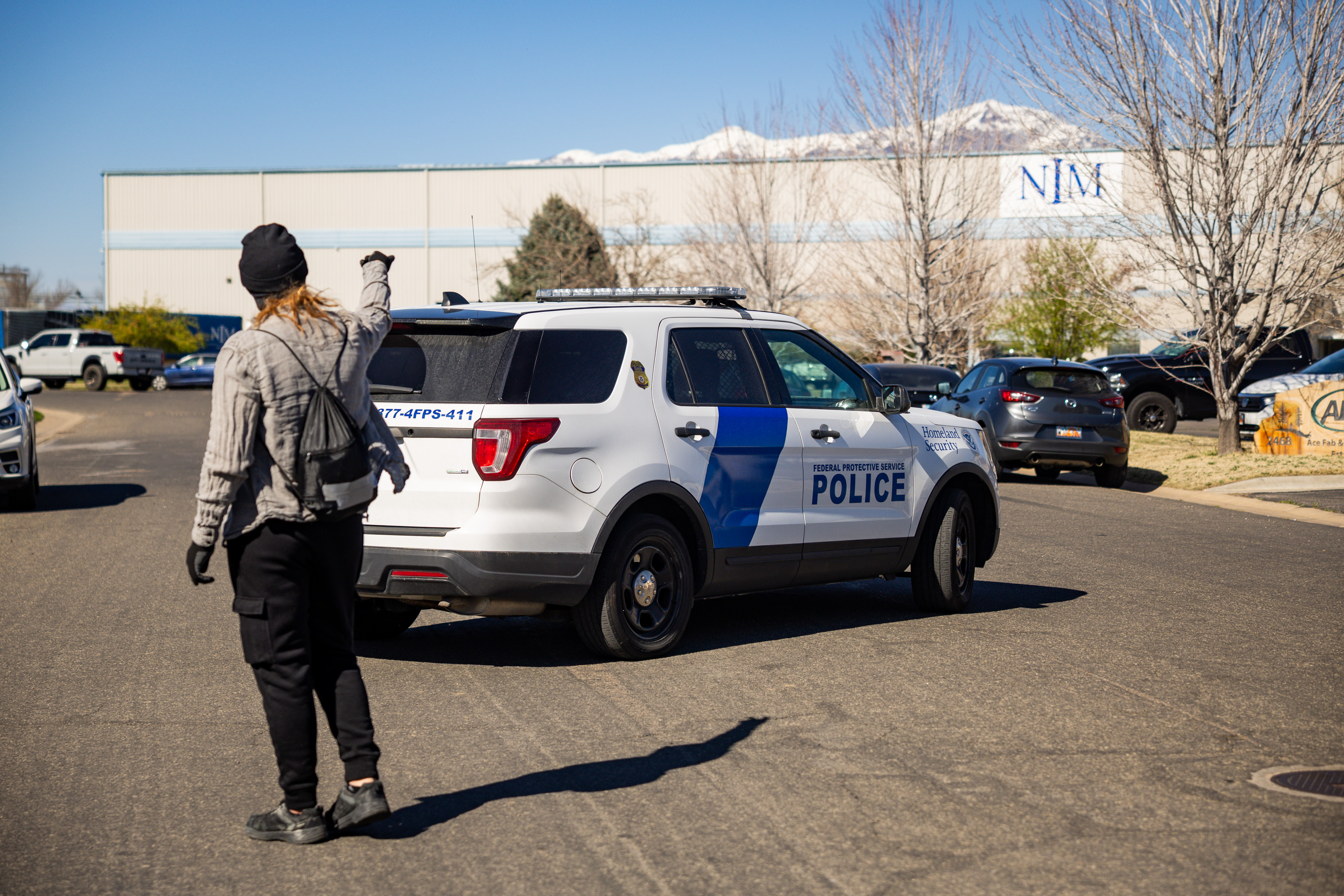 A protestor yells after a Department of Homeland Security vehicle as it exits the premises while people protest at an Immigration and Customs Enforcement office in Ogden on Friday.