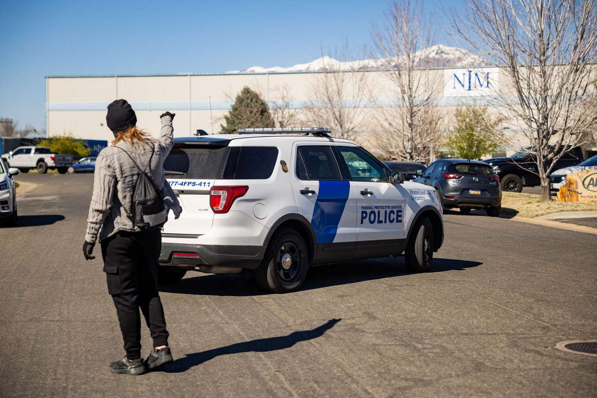 A protestor yells after a Department of Homeland Security vehicle as it exits the premises while people protest at an Immigration and Customs Enforcement office in Ogden on Friday.