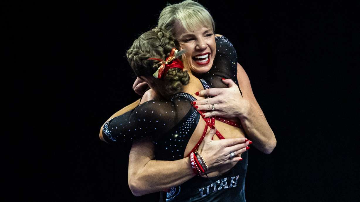 Red Rocks’ Camie Winger, left, hugs head coach Carly Dockendorf after competing in the beam during the Big 12 gymnastics championships at the Maverik Center in West Valley City on Saturday, March 21, 2026.