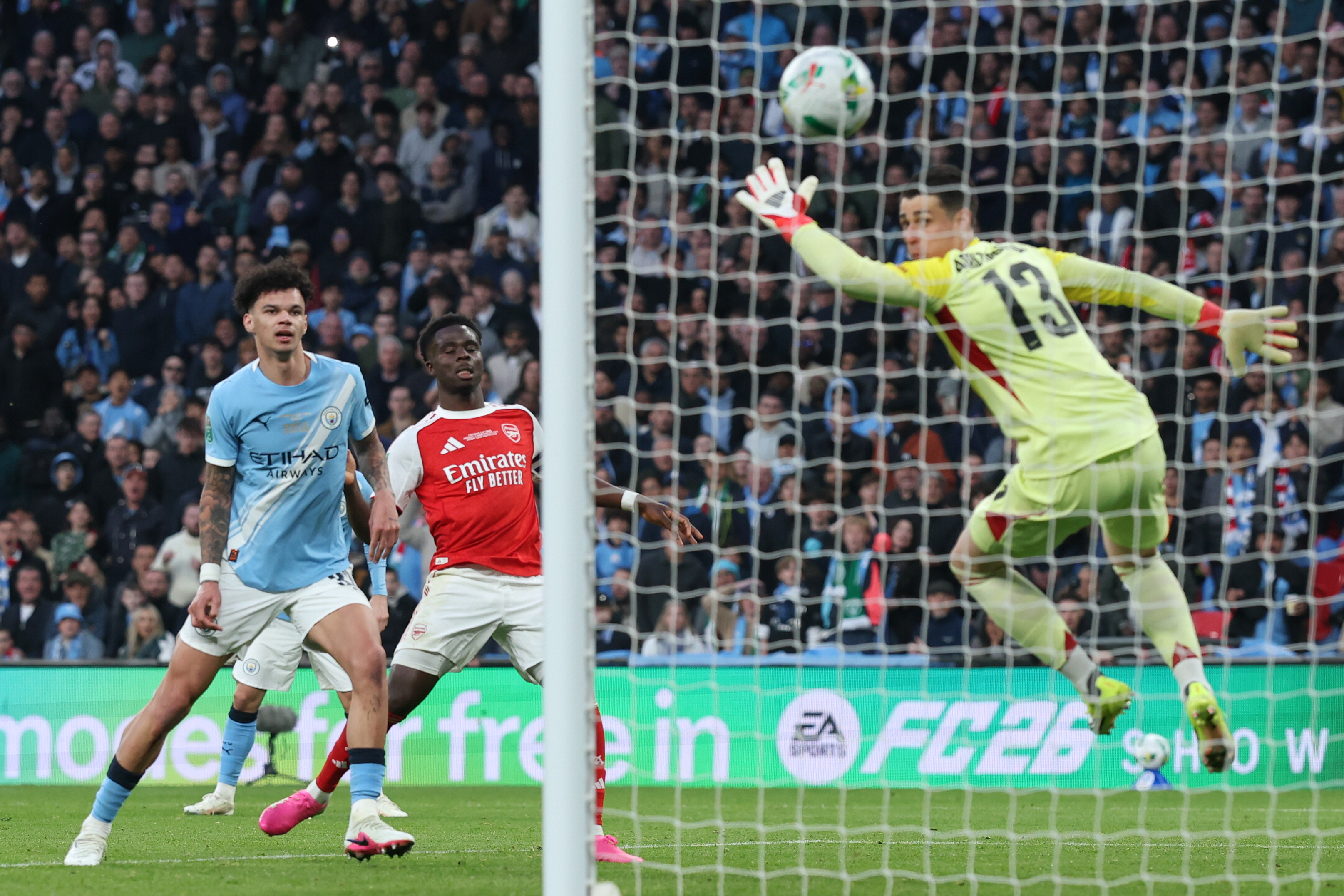 Manchester City's Nico O'Reilly, left, scores his side's second goal during the English League Cup final soccer match between Arsenal and Manchester City in London, Sunday, March 22, 2026. 