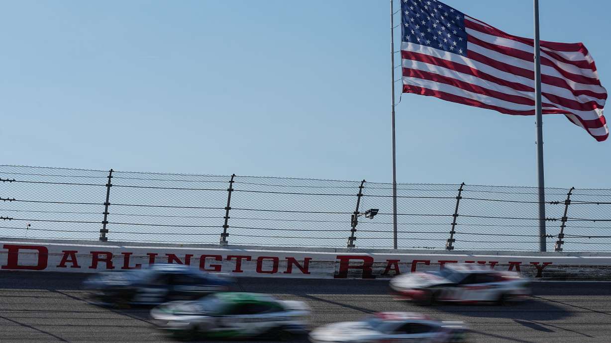 A pack of cars compete through Turn 3 during a NASCAR Cup Series auto race, Sunday, March 22, 2026, in Darlington, S.C.