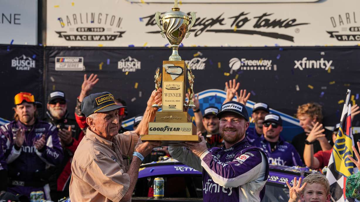 Tyler Reddick, center right, celebrates with his team in Victory Lane after winning a NASCAR Cup Series auto race, Sunday, March 22, 2026, in Darlington, S.C.