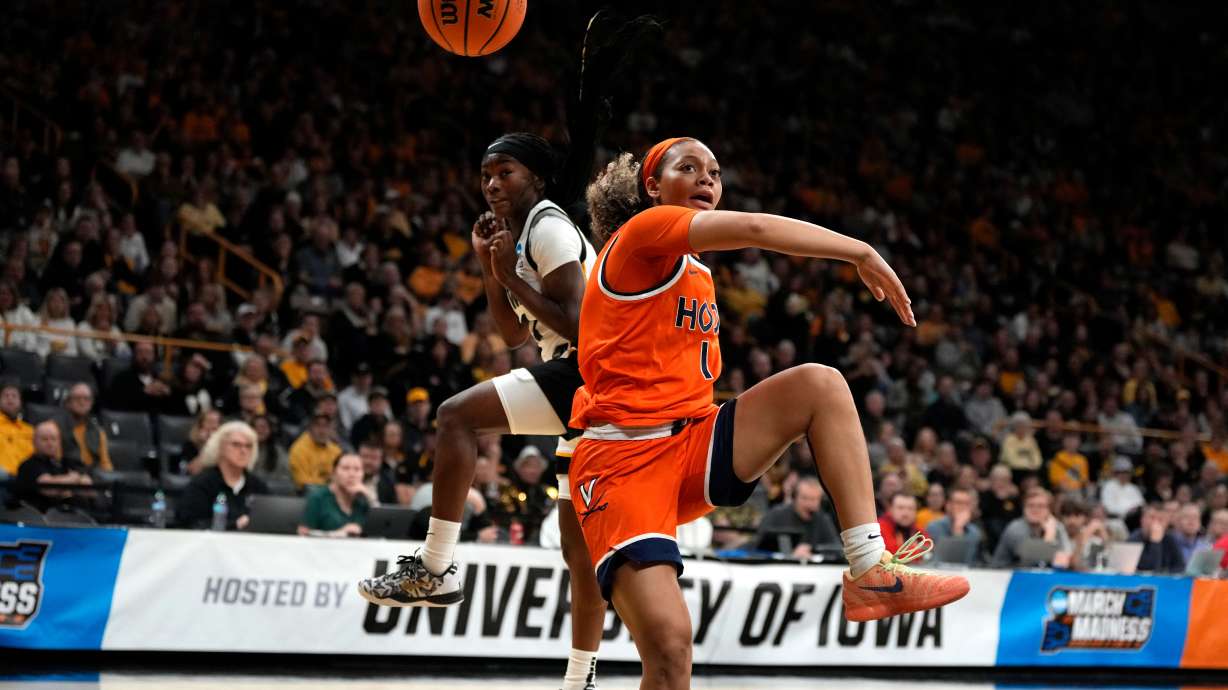 Virginia guard Paris Clark (1) fights for a loose ball with Iowa guard Chazadi Wright, left, during the first half in the second round of the NCAA college basketball tournament, Monday, March 23, 2026, in Iowa City, Iowa.