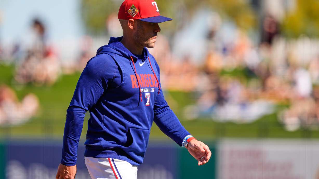 Texas Rangers manager Skip Schumaker walks back to the dugout after making a pitching change during the second inning of a spring training baseball game against the Colorado Rockies, Sunday, Feb. 22, 2026, in Surprise, Ariz.