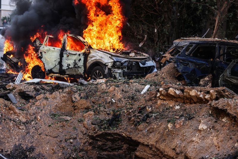 Fire engulfs a car at a site following Iranian missile barrages in central Israel, amid the U.S.-Israel conflict with Iran, in Tel Aviv, Israel, Tuesday.