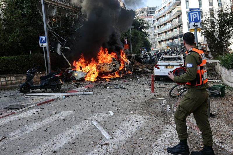 An emergency worker walks at a site following Iranian missile barrages in central Israel, amid the U.S.-Israel conflict with Iran, in Tel Aviv, Israel, Tuesday.