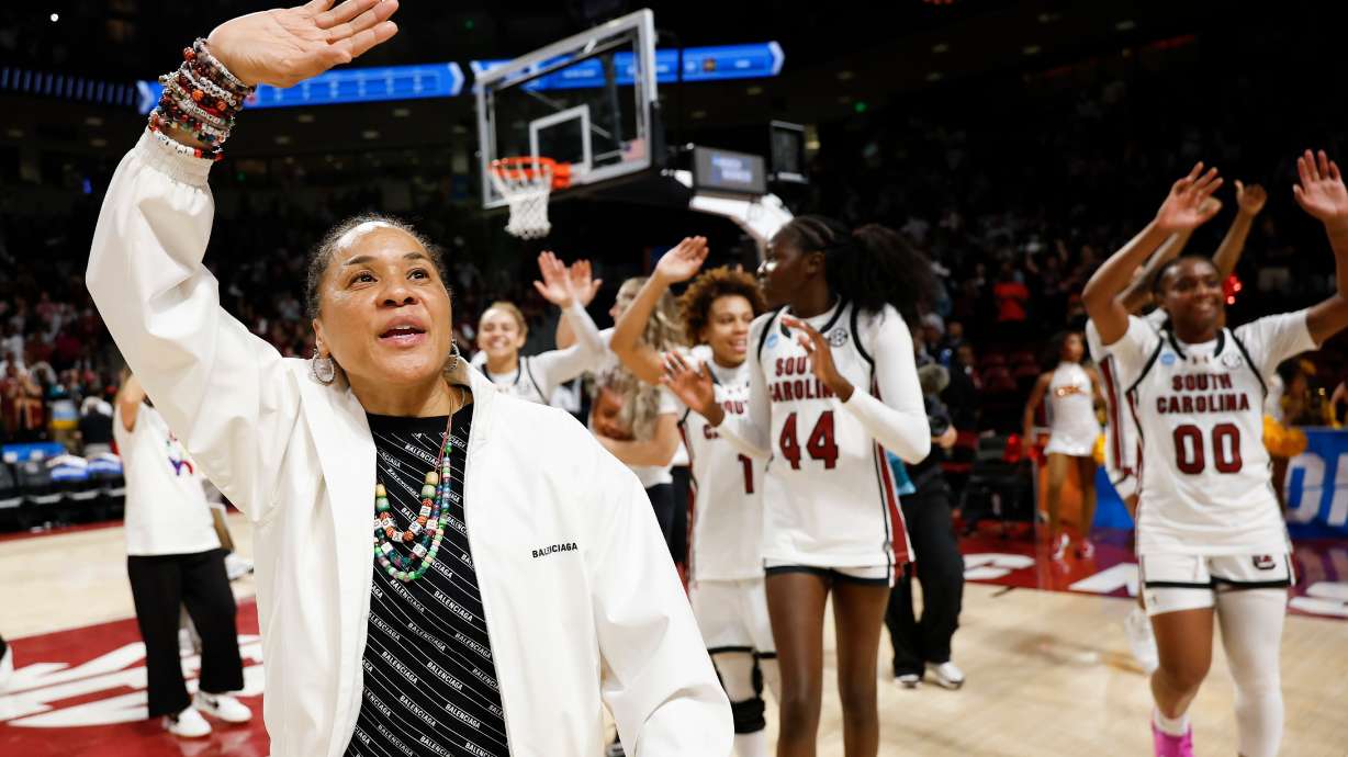 South Carolina head coach Dawn Staley, left, leads her team in waving to supporters after defeating Southern California in the second round of the NCAA college basketball tournament, Monday, March 23, 2026, in Columbia, S.C.