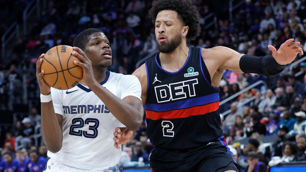 Memphis Grizzlies forward Cedric Coward (23) drives against Detroit Pistons guard Cade Cunningham (2) during the first half of an NBA basketball game Friday, March 13, 2026, in Detroit.