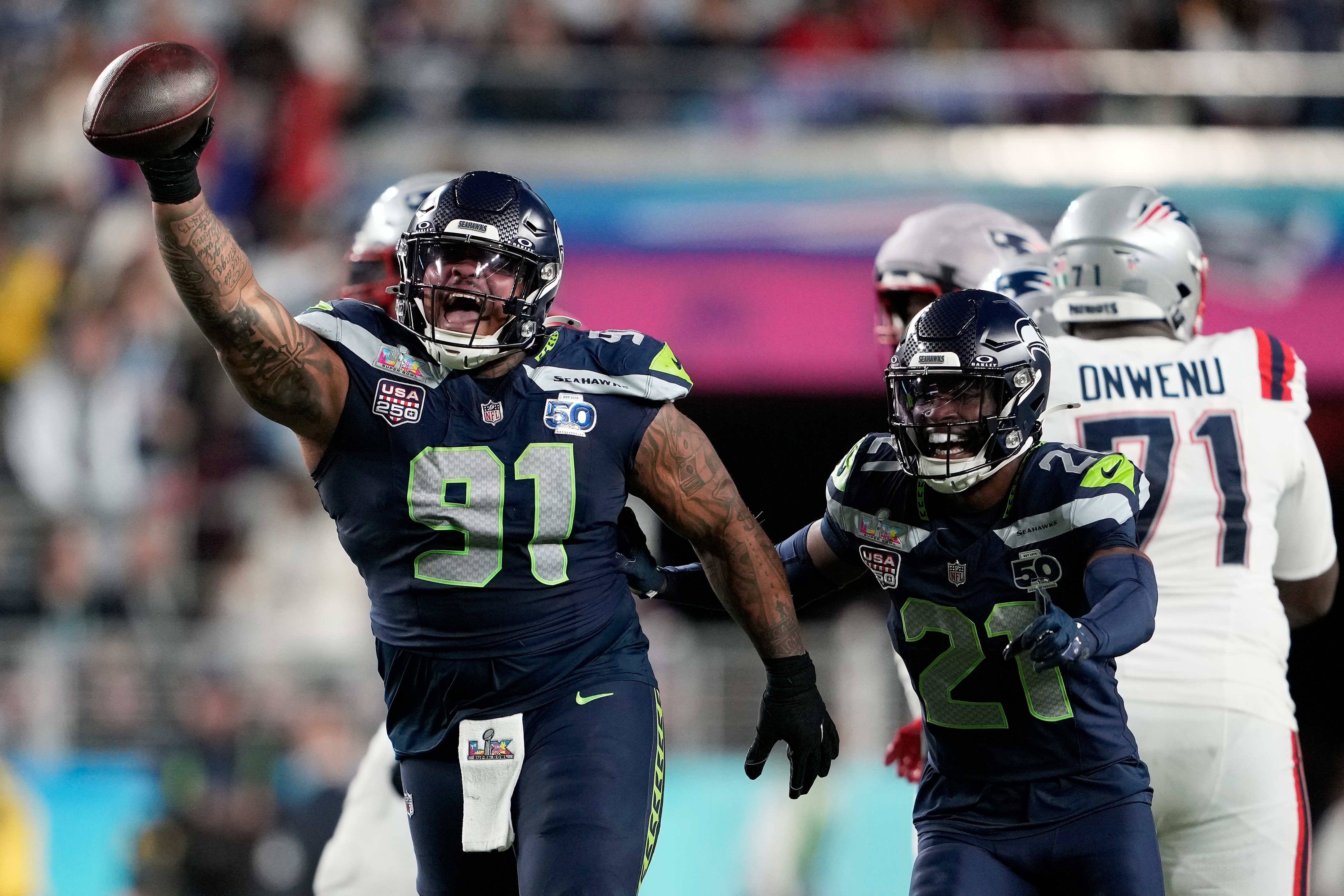 FILE - Seattle Seahawks defensive tackle Byron Murphy II (91) celebrates with cornerback Devon Witherspoon (21) after recovering a fumble by New England Patriots quarterback Drake Maye during the second half of the NFL Super Bowl 60 football game, Feb. 8, 2026, in Santa Clara, Calif.