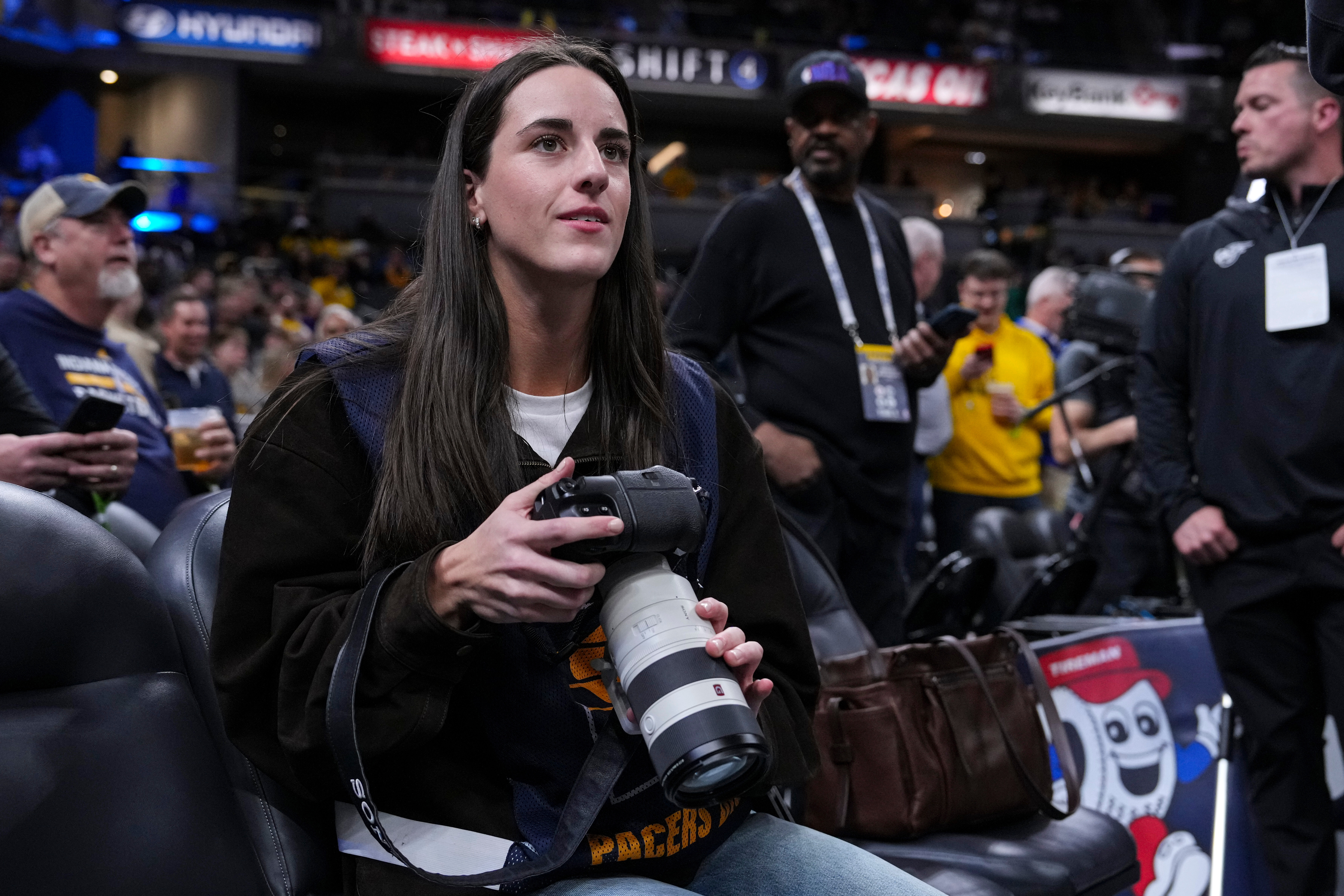 Indiana Fever guard Caitlyn Clark takes photos during pregame before an NBA basketball game between the Indiana Pacers and the Los Angeles Lakers in Indianapolis, Wednesday, March 25, 2026. 