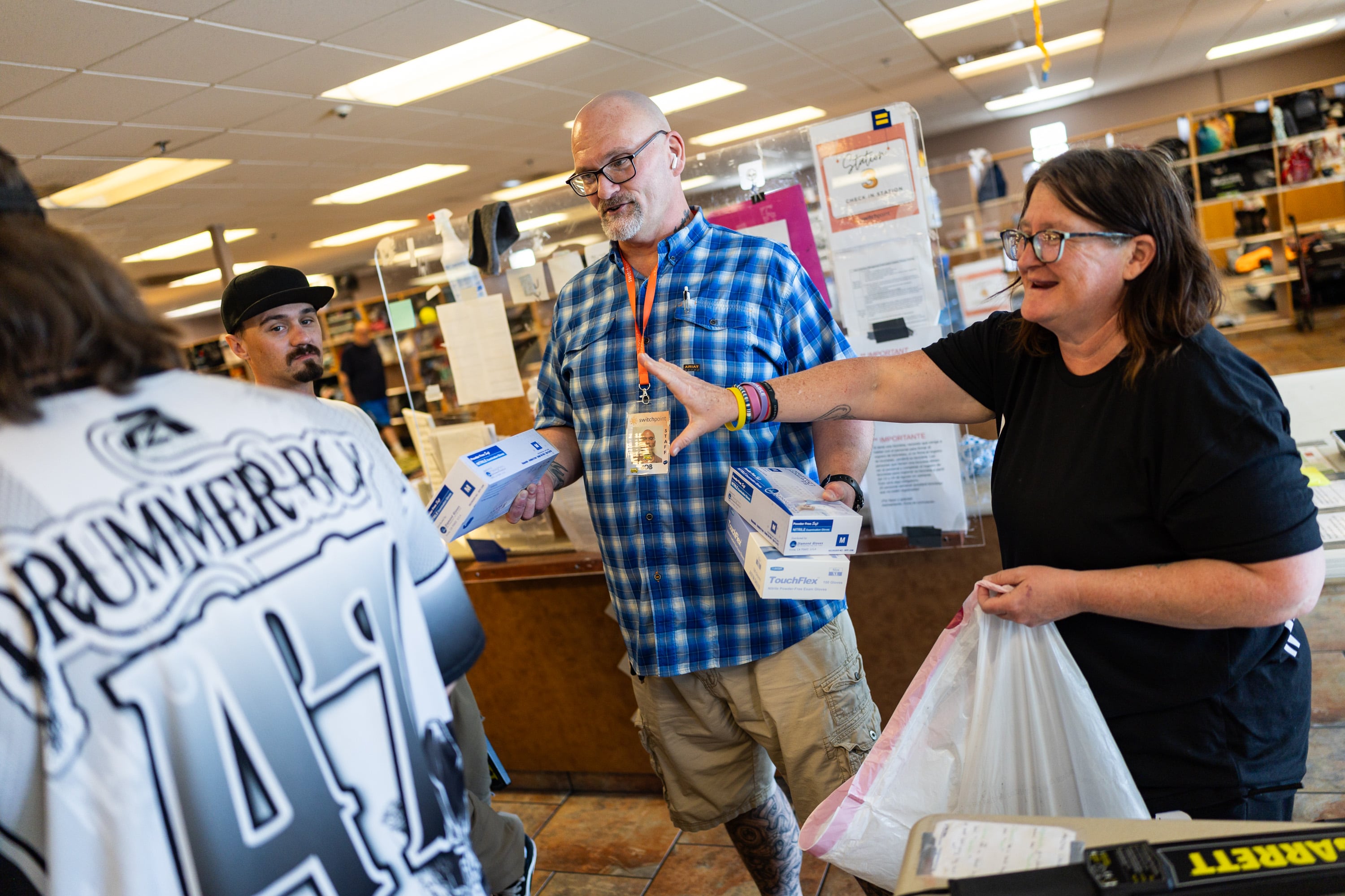 Robert Alewine, swing-shift exit lead and support staff, center, and fellow employee Misty Davis, right, gather gloves with other staffers at Switchpoint's Salt Lake Overflow Shelter in West Valley City on Wednesday.
