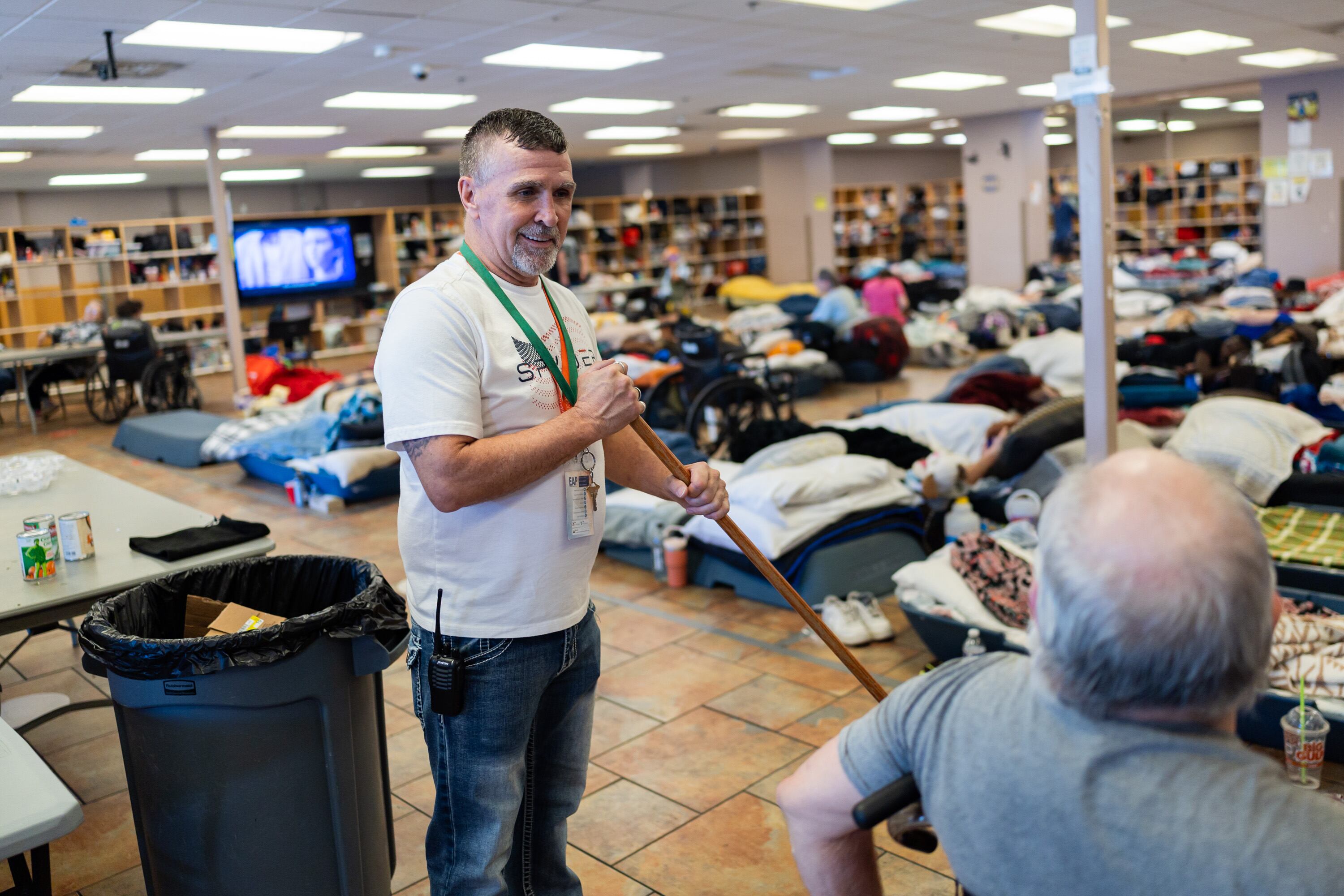 Gordon Smith, resident support staff, talks to a guest while mopping at Switchpoint's Salt Lake Overflow Shelter in West Valley City on Wednesday.