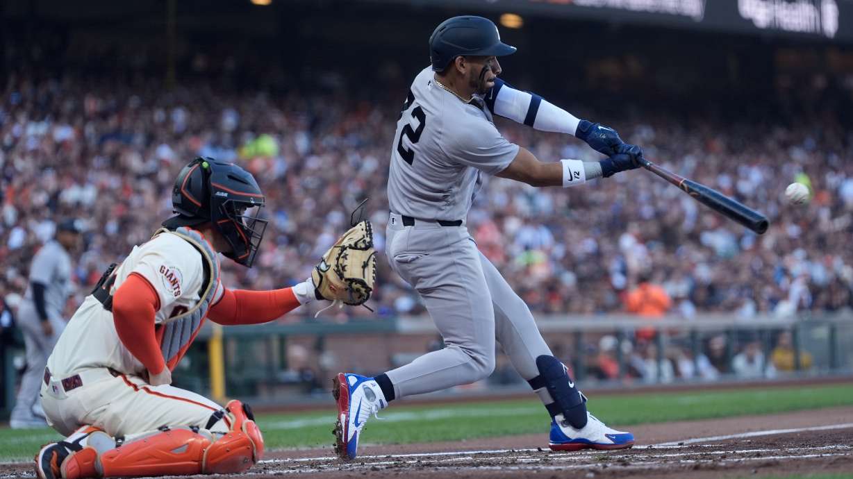 New York Yankees' José Caballero, right, hits an RBI double in front of San Francisco Giants catcher Patrick Bailey, left, during the second inning of a baseball game in San Francisco, Wednesday, March 25, 2026.