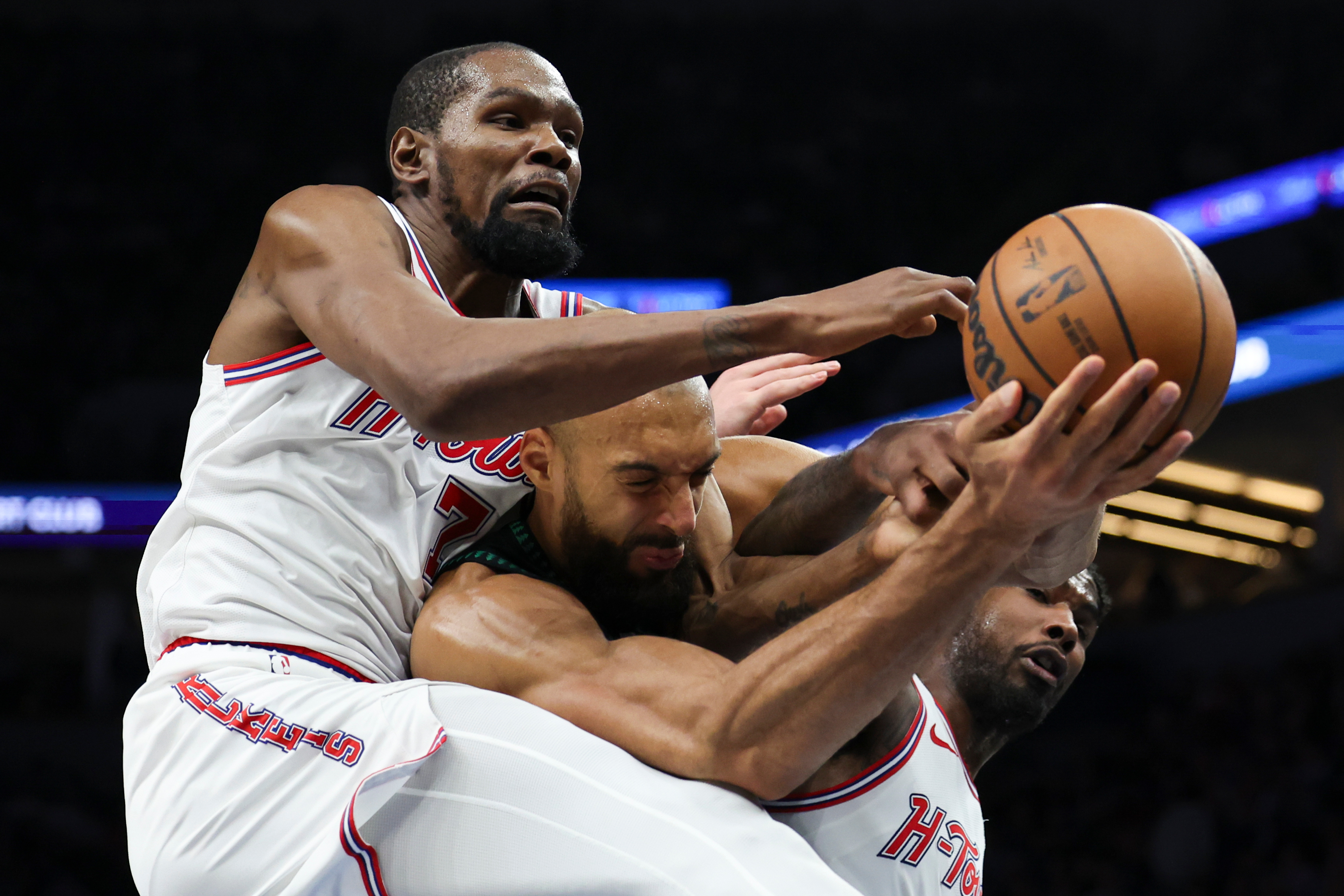 Houston Rockets forward Kevin Durant (7), Minnesota Timberwolves center Rudy Gobert, center, and Houston Rockets guard Amen Thompson, right, compete for a rebound during the first half of an NBA basketball game, Wednesday, March 25, 2026, in Minneapolis. 