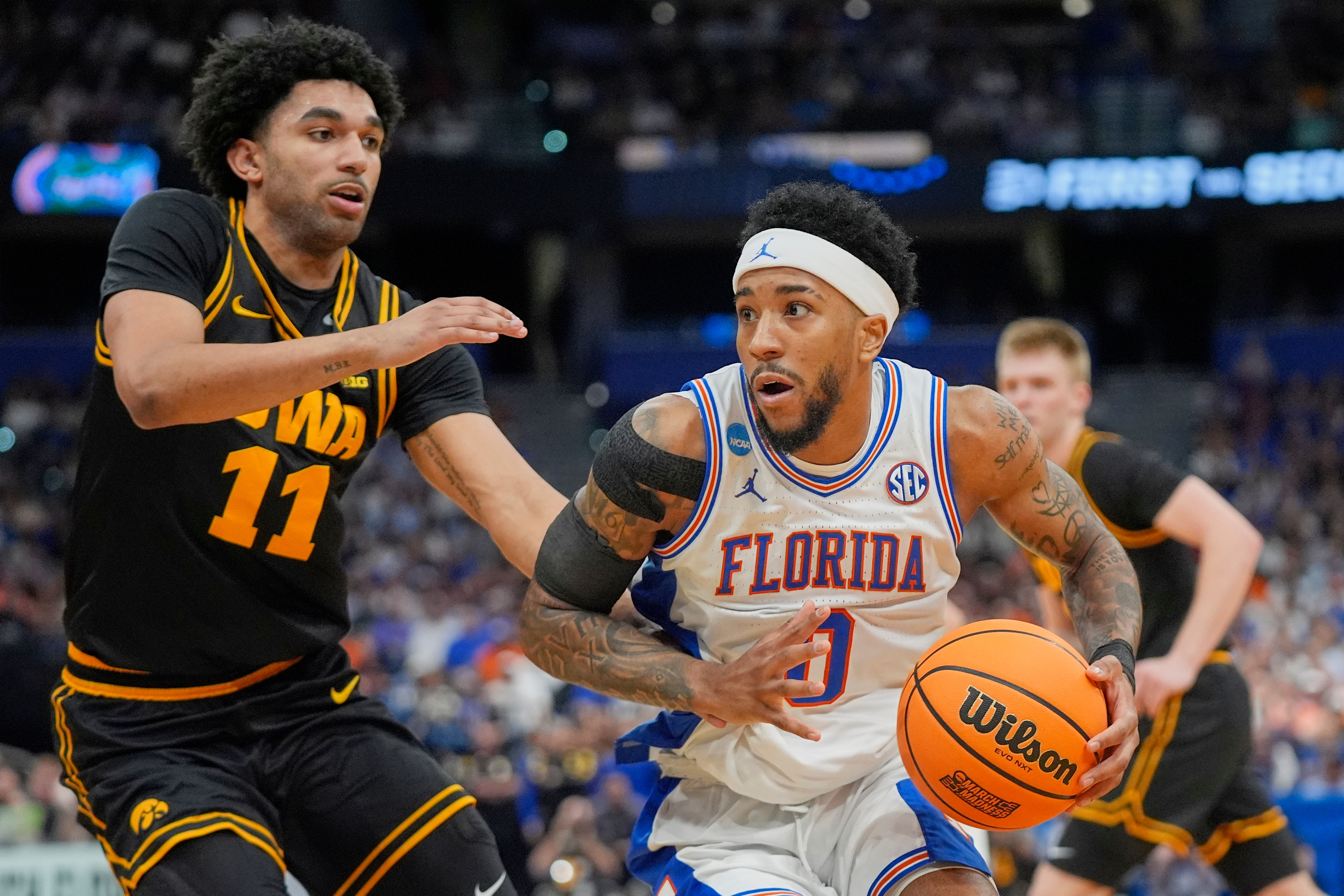 Florida guard Boogie Fland, right, drives around Iowa guard Kael Combs (11) during the first half in the second round of the NCAA college basketball tournament, Sunday, March 22, 2026, in Tampa, Fla. 