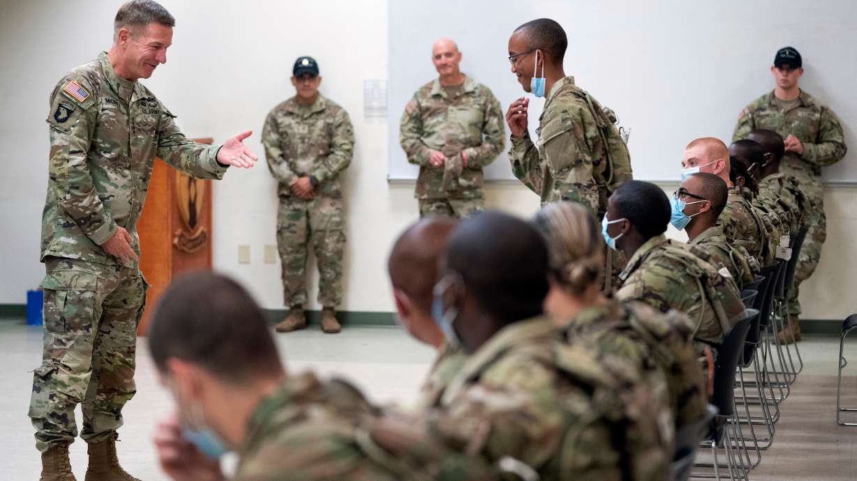 Chief of Staff of the Army Gen. James McConville left, gestures to a student in the new Army prep course at Fort Jackson, S.C., Aug. 26, 2022. The Army will now allow people in their early 40s to join.
