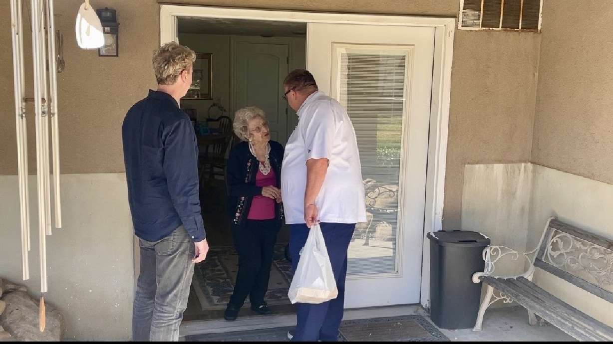 Lehi resident Wilma Hofheins receives her Meals on Wheels delivery by Mayor Paul Binns (right) and volunteer Jason Rawlins (left) on Wednesday.