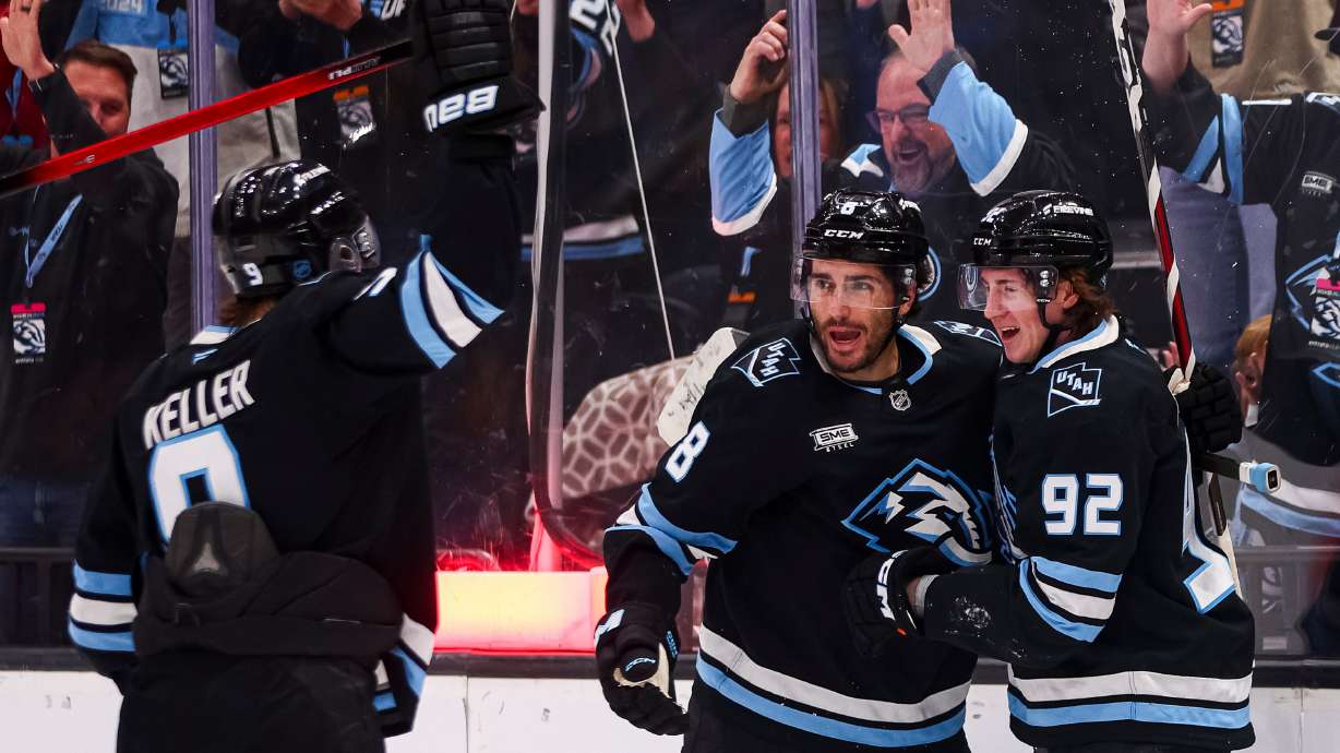 Utah Mammoth center Logan Cooley (92) celebrates with center Nick Schmaltz (8) and right wing Clayton Keller (9) after scoring during the first period of an NHL game against the Washington Capitals at the Delta Center in Salt Lake City on Thursday, March 26, 2026.