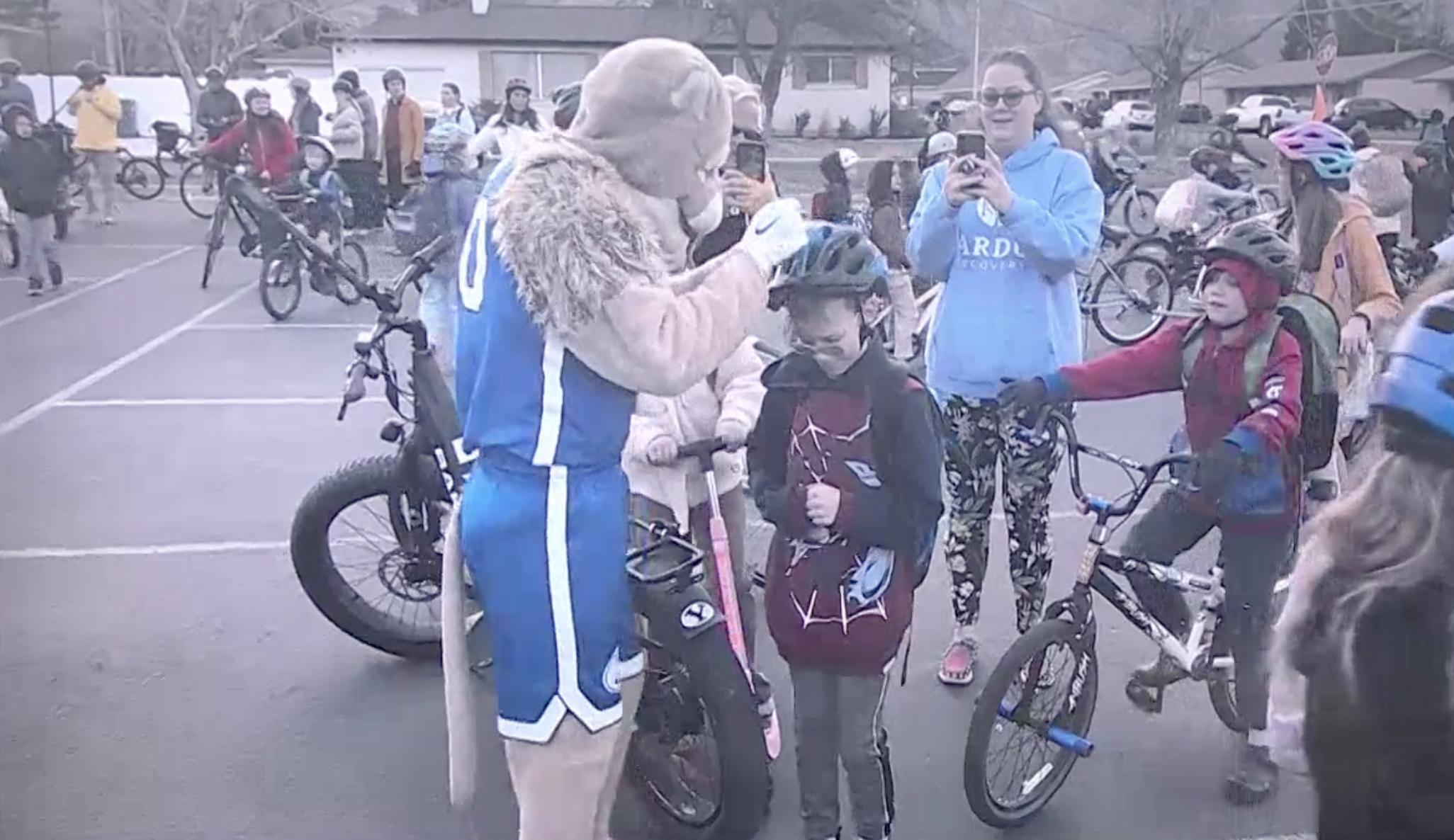 Parents and students join together with Cosmo the Cougar on Friday for the Cascade Elementary bike bus in Orem.