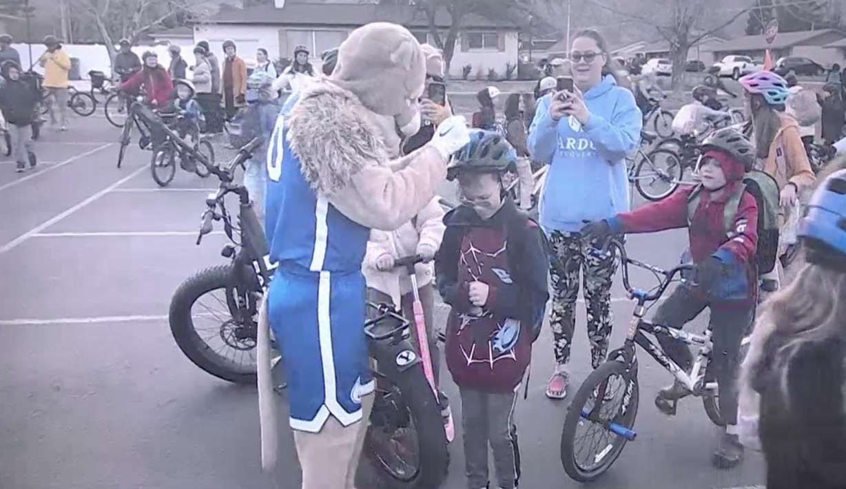 Parents and students join together with Cosmo the Cougar on Friday for the Cascade Elementary bike bus in Orem.