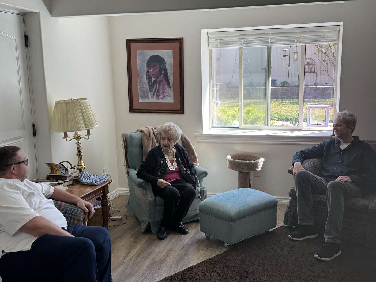 Lehi resident Wilma Hofheins is visited by Mayor Paul Binns (left) and volunteer Jason Rawlins (right) during a Meals on Wheels delivery on Wednesday.