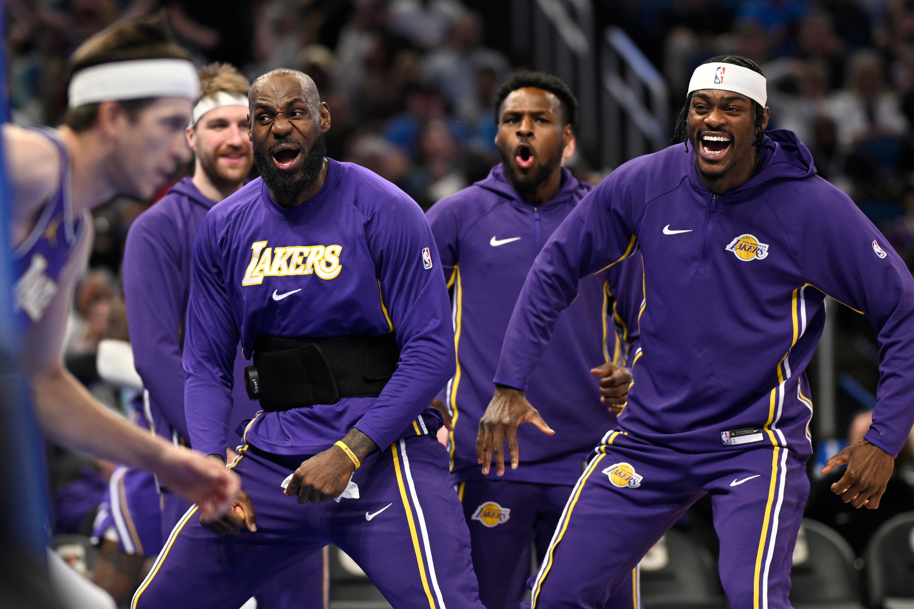 Los Angeles Lakers forward LeBron James, second from front right, and forward Jarred Vanderbilt, right, react after a dunk by guard Austin Reaves, left, during the first half of an NBA basketball game against the Orlando Magic, Saturday, March 21, 2026, in Orlando, Fla. 