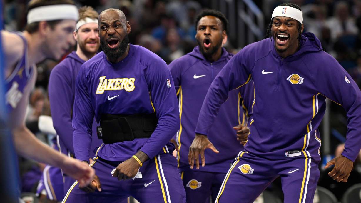 Los Angeles Lakers forward LeBron James, second from front right, and forward Jarred Vanderbilt, right, react after a dunk by guard Austin Reaves, left, during the first half of an NBA basketball game against the Orlando Magic, Saturday, March 21, 2026, in Orlando, Fla.