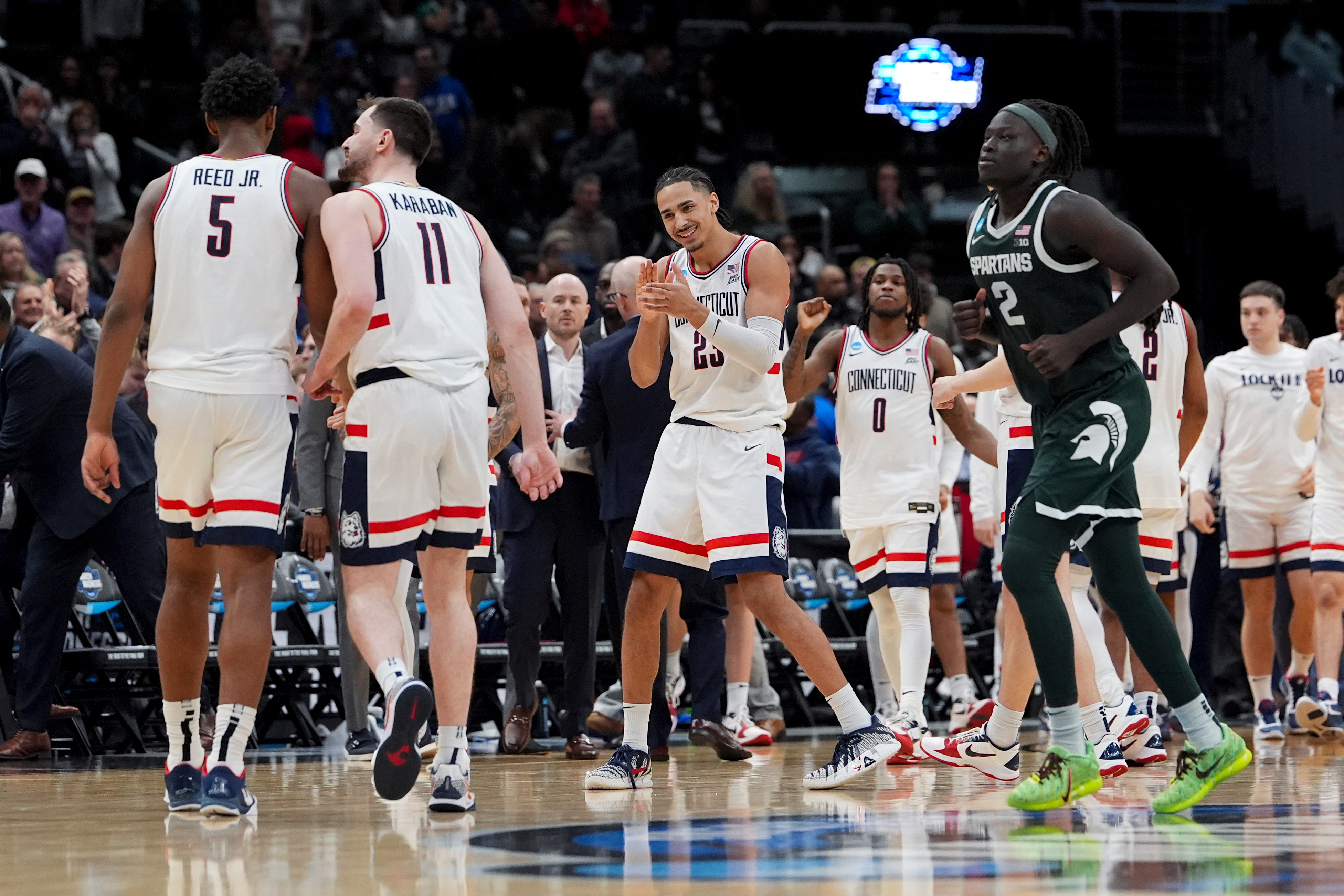 UConn forward Jayden Ross (23) celebrates with forward Tarris Reed Jr. (5) and forward Alex Karaban (11) against Michigan State during the second half in the Sweet 16 of the NCAA college basketball tournament, Saturday, March 28, 2026, in Washington. 