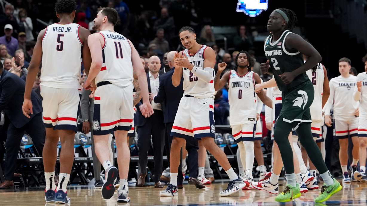 UConn forward Jayden Ross (23) celebrates with forward Tarris Reed Jr. (5) and forward Alex Karaban (11) against Michigan State during the second half in the Sweet 16 of the NCAA college basketball tournament, Saturday, March 28, 2026, in Washington.