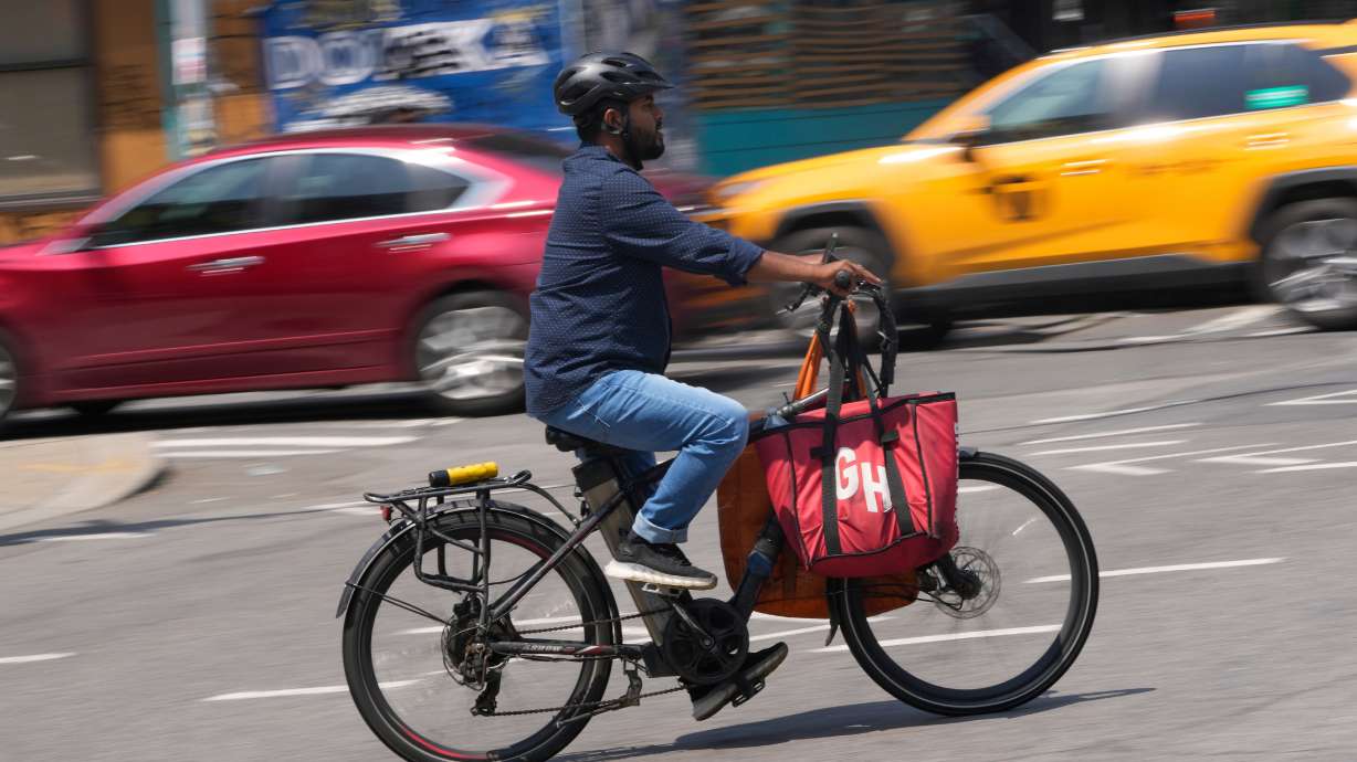 A delivery worker rides an electric bicycle in New York, July 25, 2023. E-bikes offer a convenient, eco-friendly and cost-effective alternative to cars, but their increasing use is drawing safety concerns.