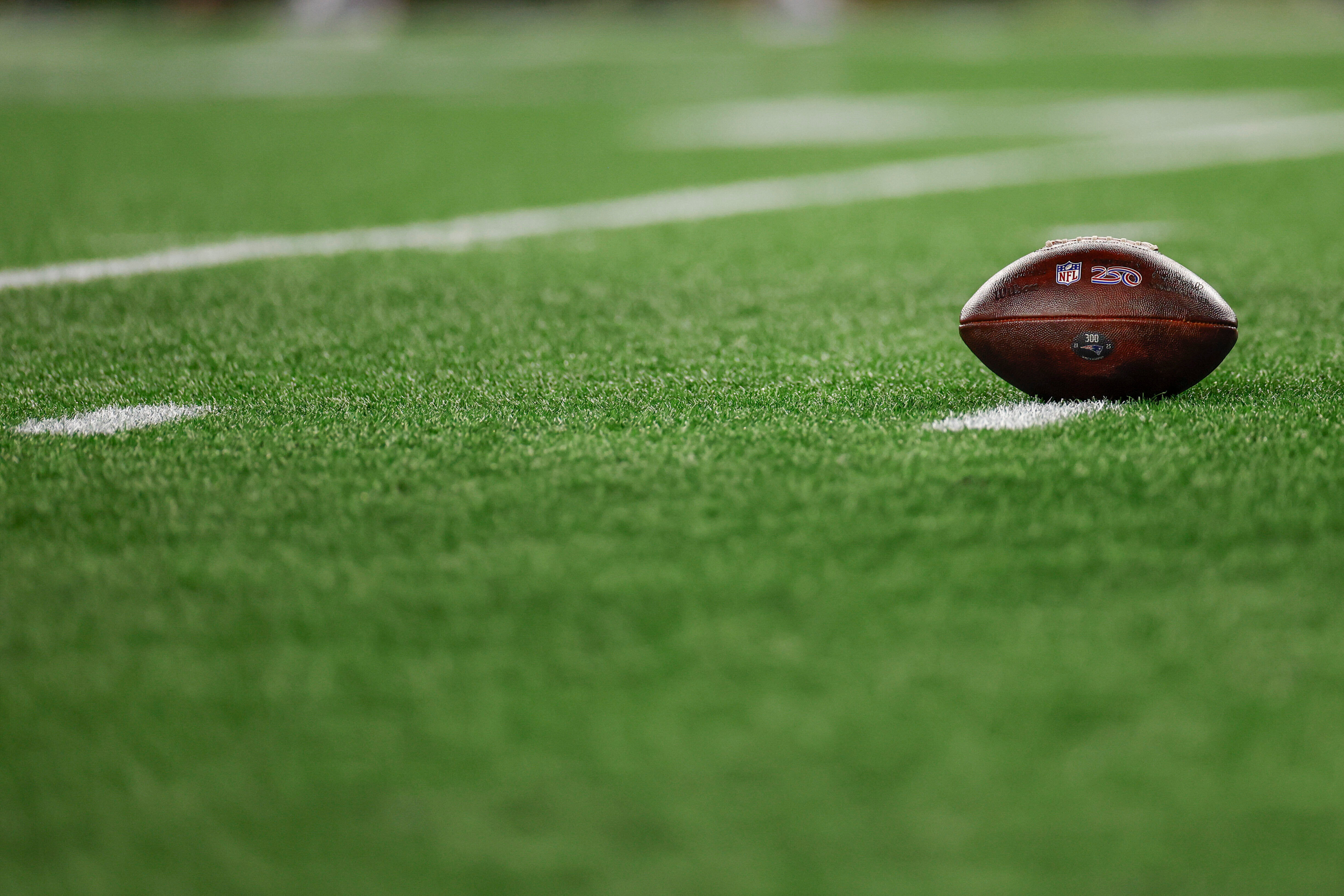 FILE - A football with the NFL shield logo rests on the turf during the second half of an NFL wild card playoff football game between the New England Patriots and the Los Angeles Chargers, Jan. 11, 2026, in Foxborough, Mass. 