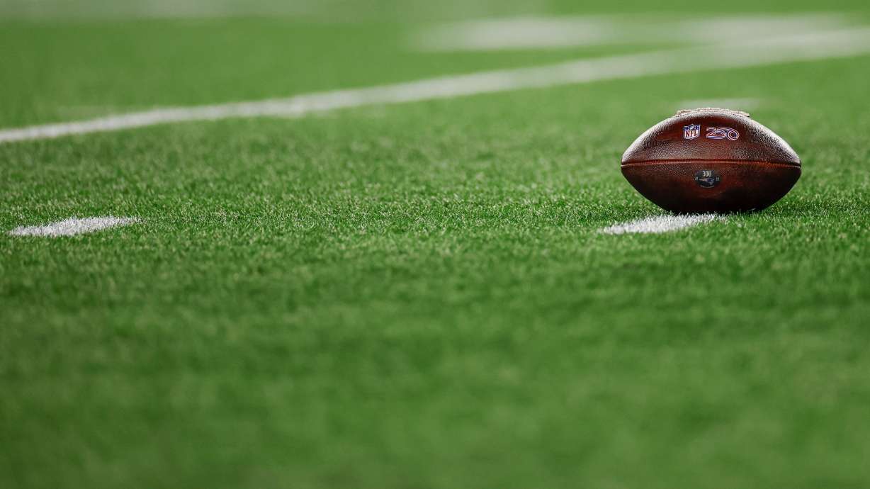 FILE - A football with the NFL shield logo rests on the turf during the second half of an NFL wild card playoff football game between the New England Patriots and the Los Angeles Chargers, Jan. 11, 2026, in Foxborough, Mass.