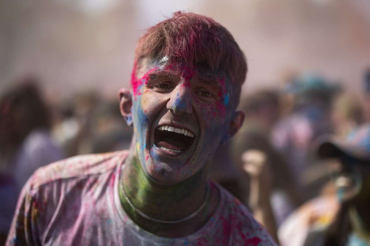 An attendee smiles and sings along to the music as people celebrate Holi at the Sri Sri Radha Krishna Temple in Spanish Fork on Saturday.