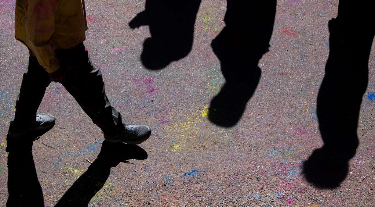 Color covers the walkway as people celebrate Holi at the Sri Sri Radha Krishna Temple in Spanish Fork on Saturday.