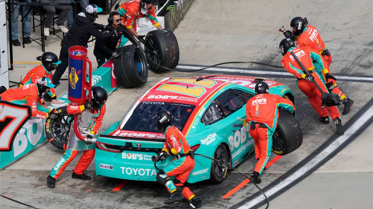 Crew members perform a pit stop on driver Denny Hamlin's car during a NASCAR Cup Series auto race in Martinsville, Va., Sunday, March 29, 2026.