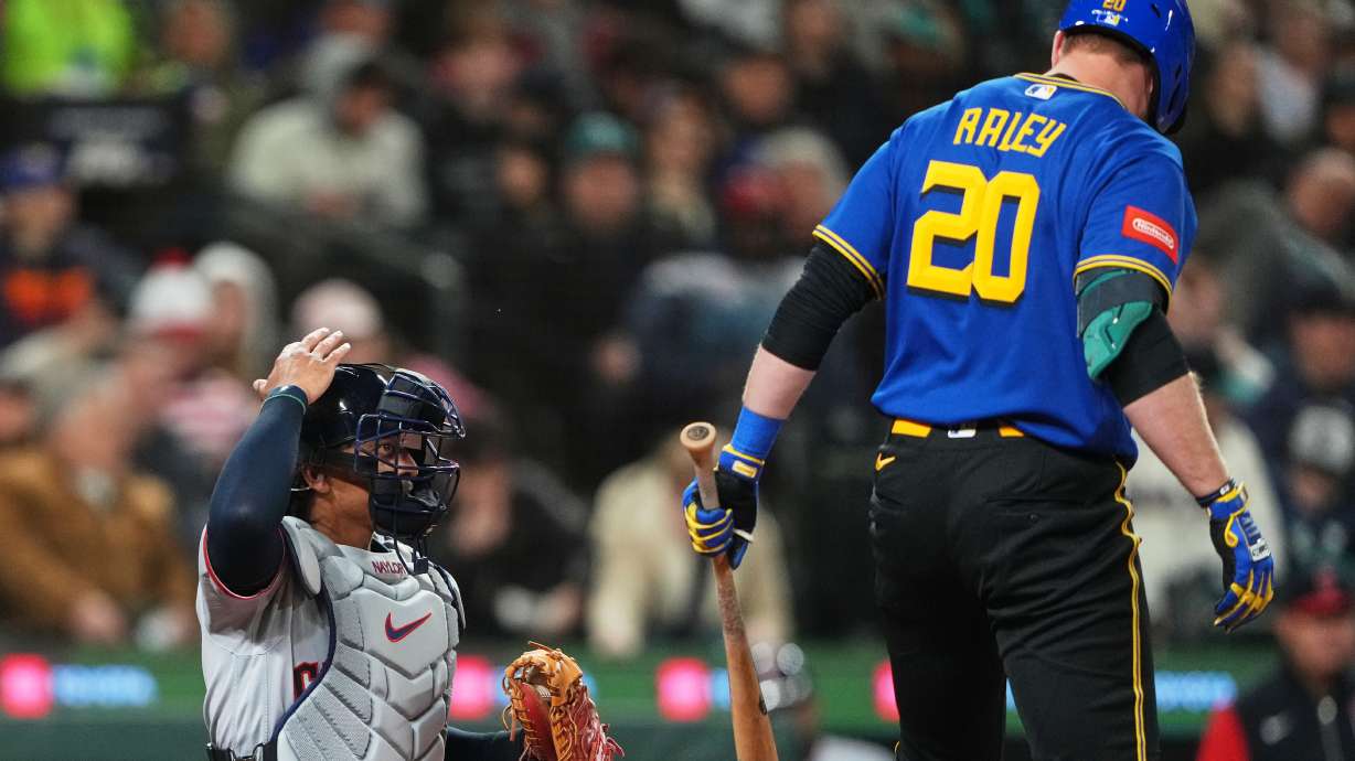 FILE - Cleveland Guardians catcher Bo Naylor challenges a call during an at-bat by Seattle Mariners' Luke Raley during the fourth inning of a baseball game, Friday, March 27, 2026, in Seattle.